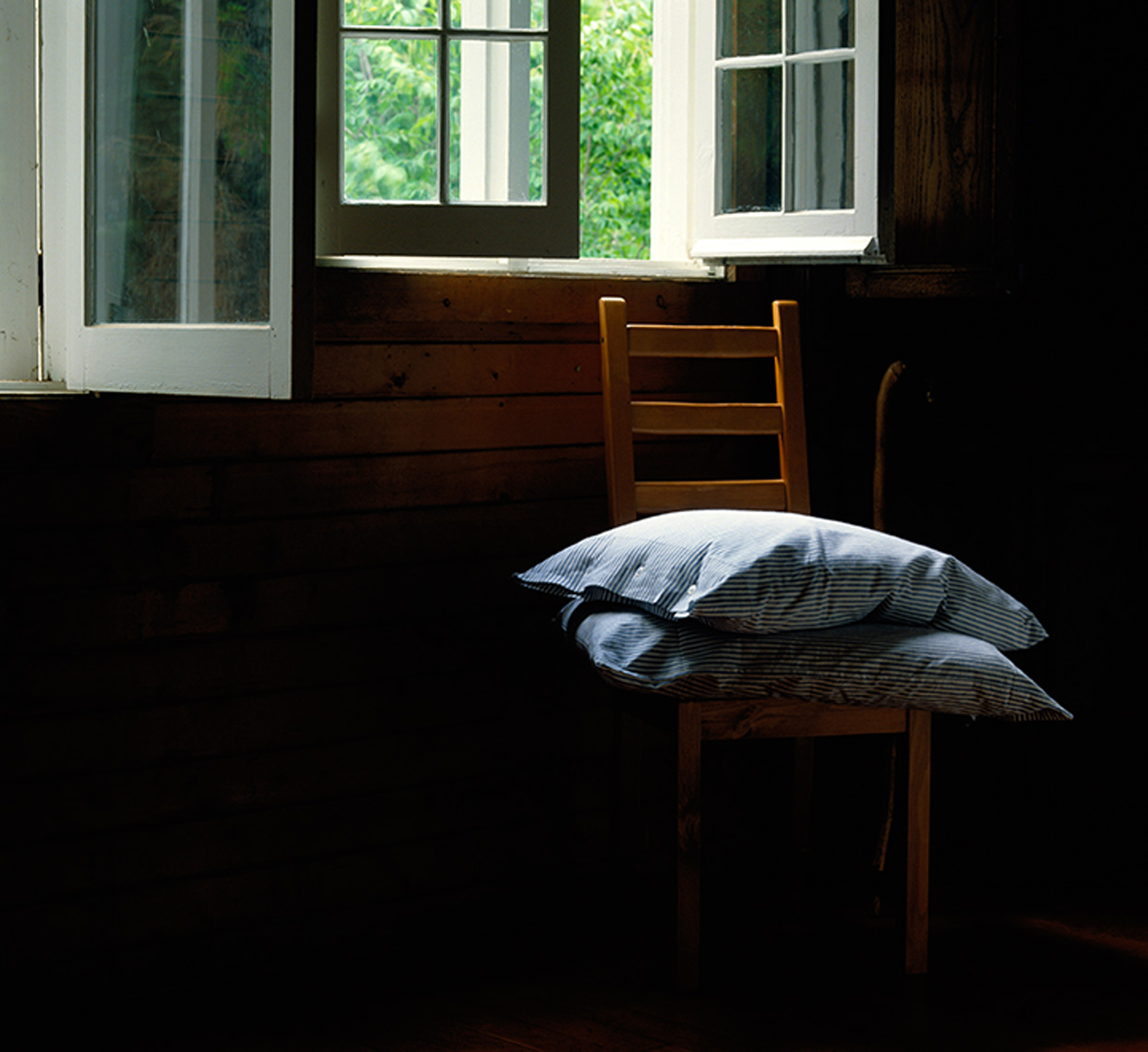 pillows on wooden  chair by window