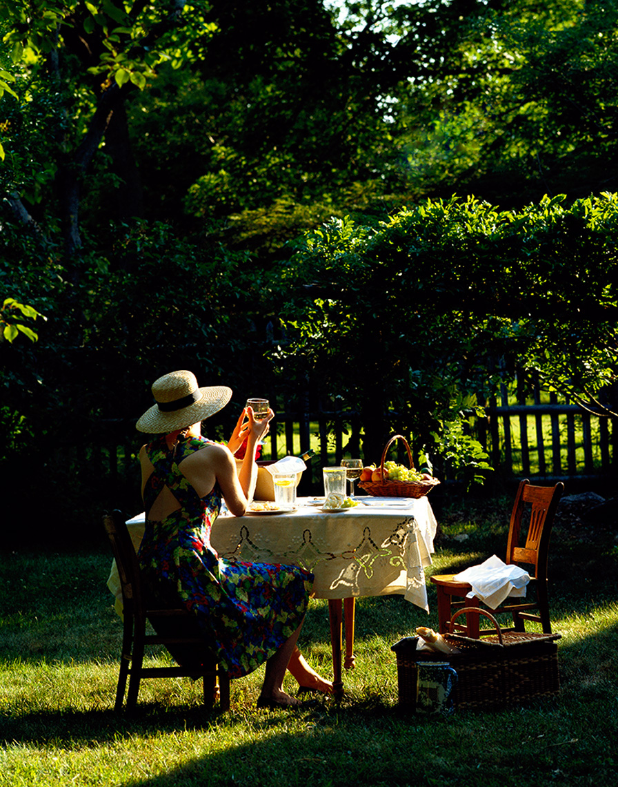 woman in yard with table wine and food