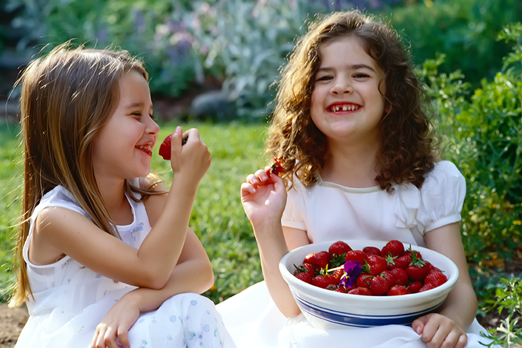 little girls eating strawberries