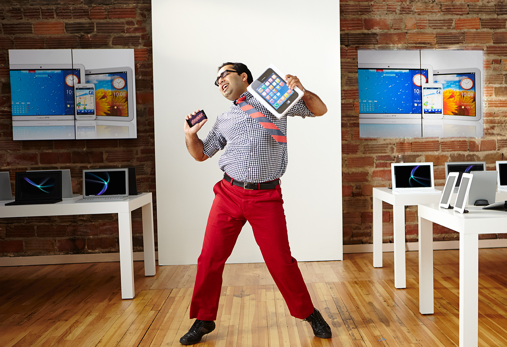 man dancing in a computer store with tablet