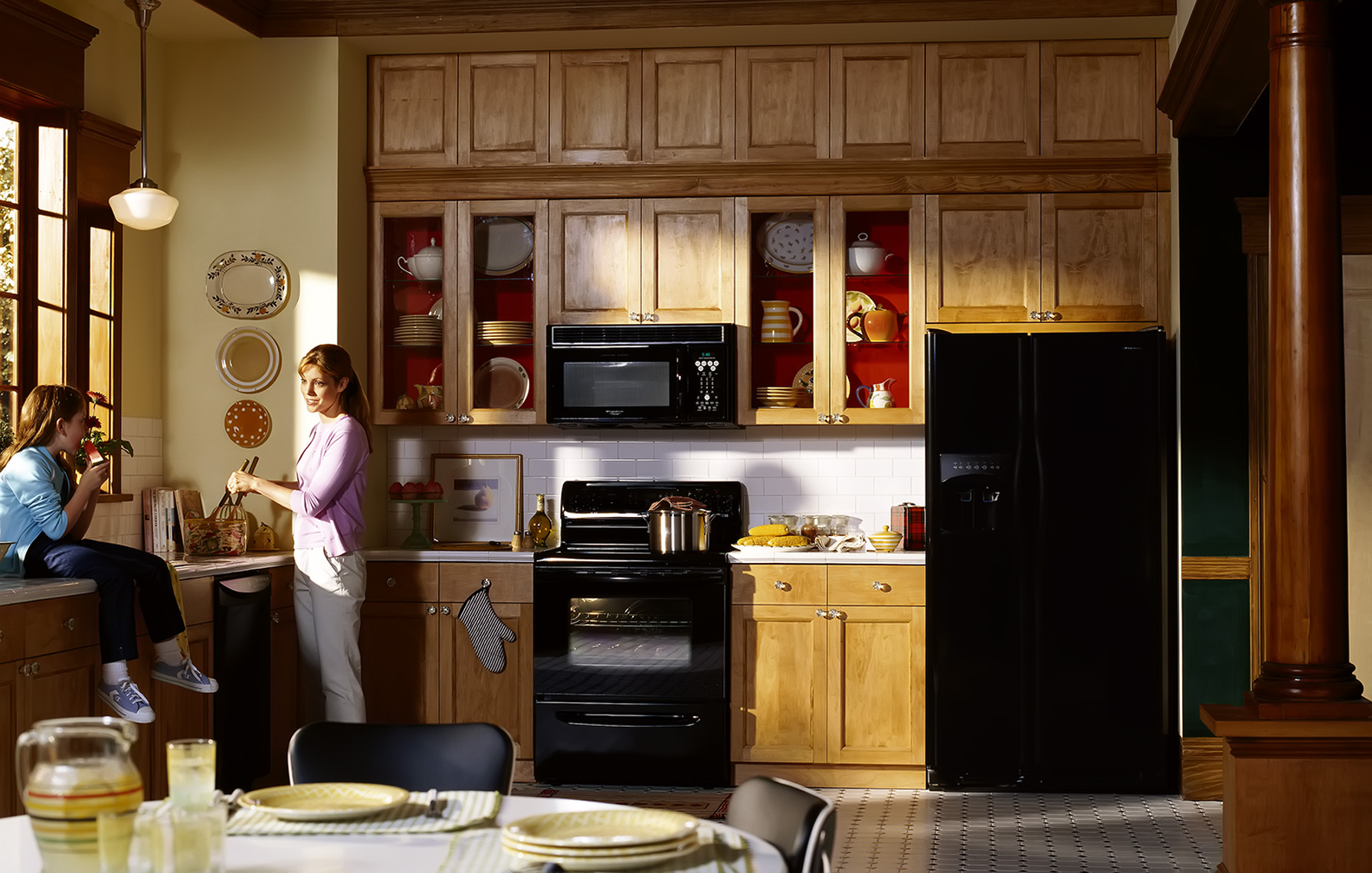 mother and daughter in kitchen with black appliances