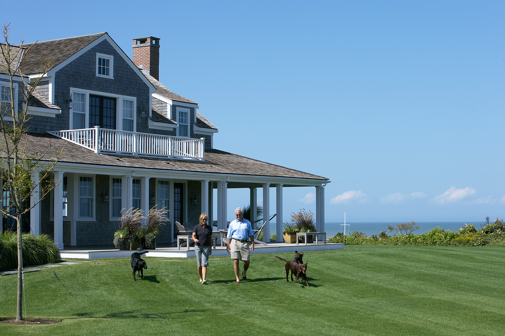 couple walking with dogs outside of their house