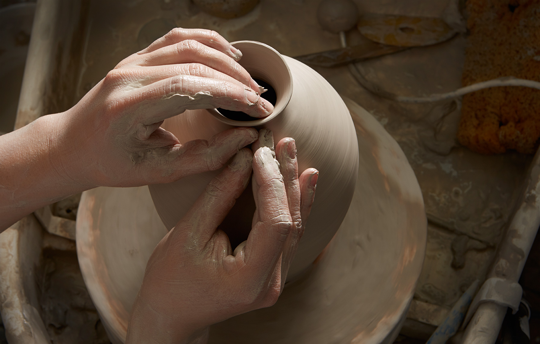 potters hands throwing clay pot