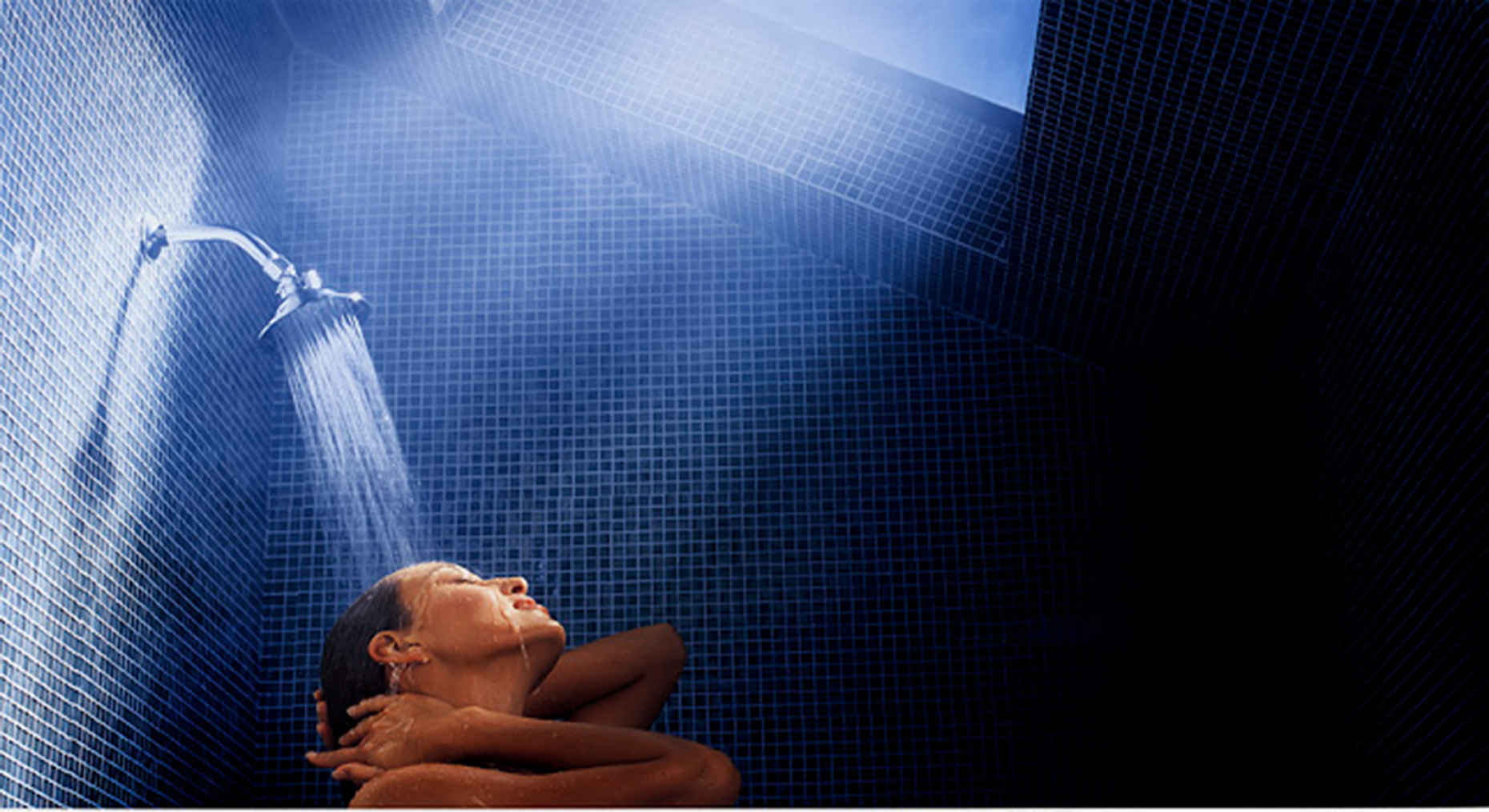woman in shower with skylight and blue tile