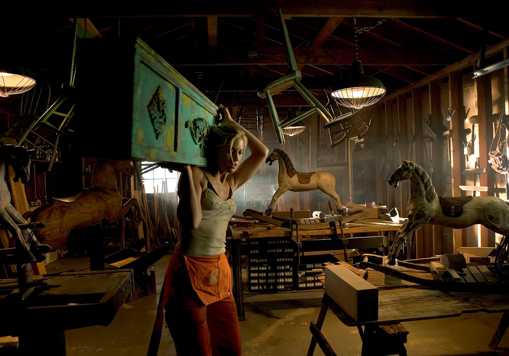 woman in orange overalls living green mantle in workshop